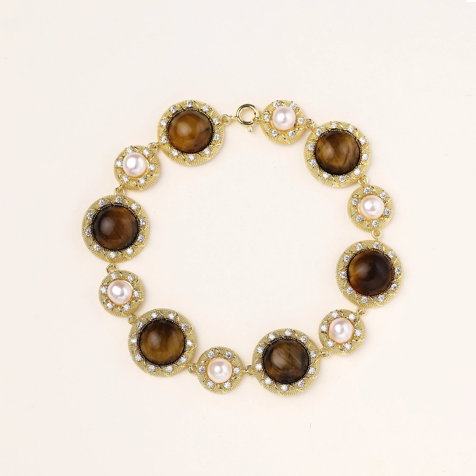Gold-plated link bracelet with alternating brown tiger's eye stones and white freshwater pearls in ornate bezels.