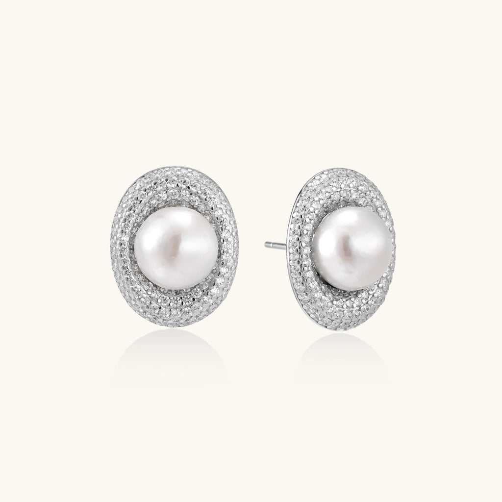 Elegant stud earrings with cream freshwater pearls surrounded by sparkly pavé crystals on rhodium-plated silver setting