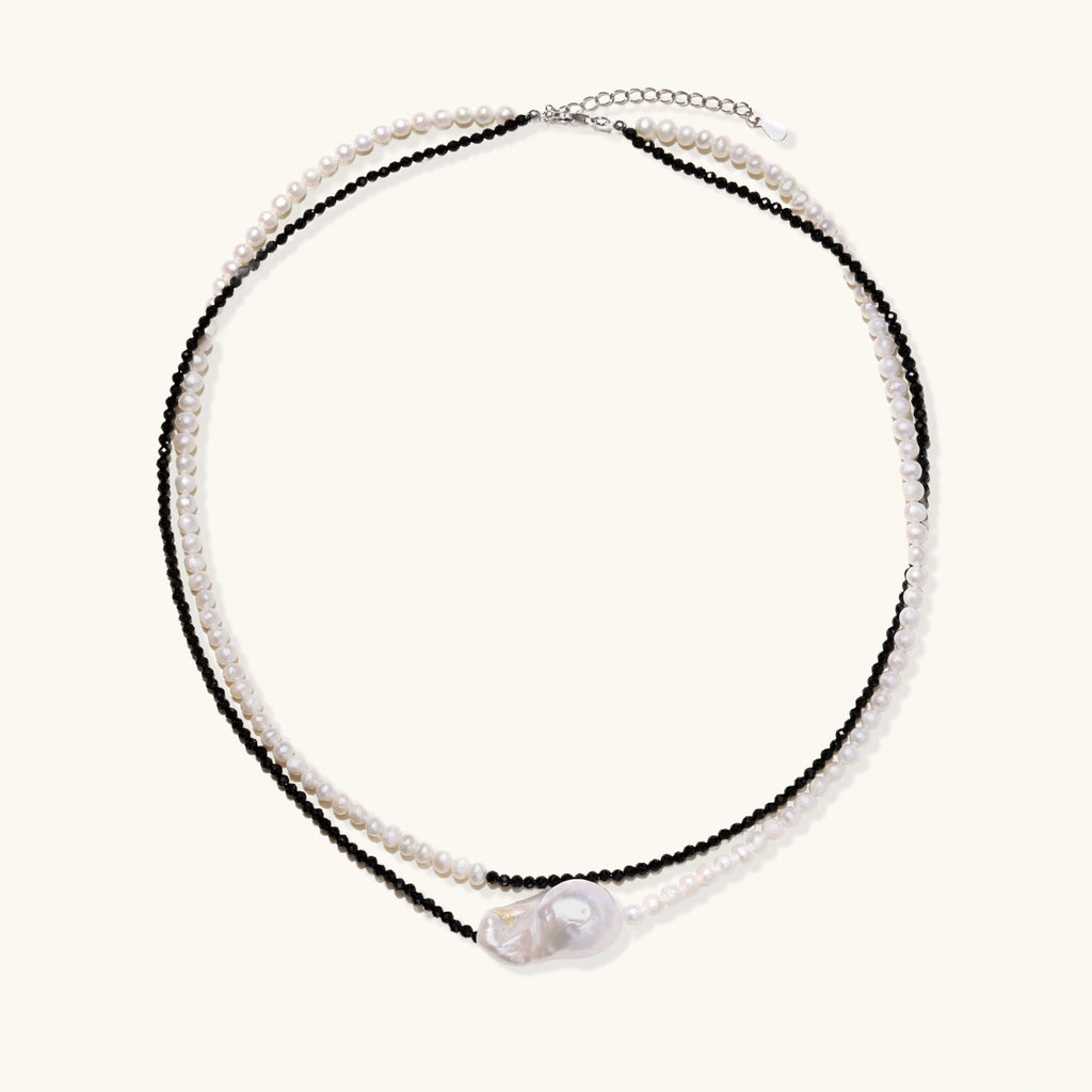 Double-strand necklace with black faceted quartz and white pearls featuring an oversized baroque pearl centerpiece