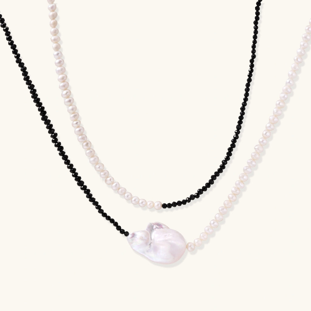 Double-strand necklace with black faceted quartz and white pearls featuring an oversized baroque pearl centerpiece