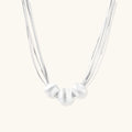 Sterling silver multi-strand necklace with three brushed round beads on cream background