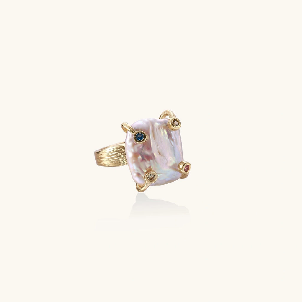 Gold ring with large iridescent baroque pearl and four colored gemstones on textured band