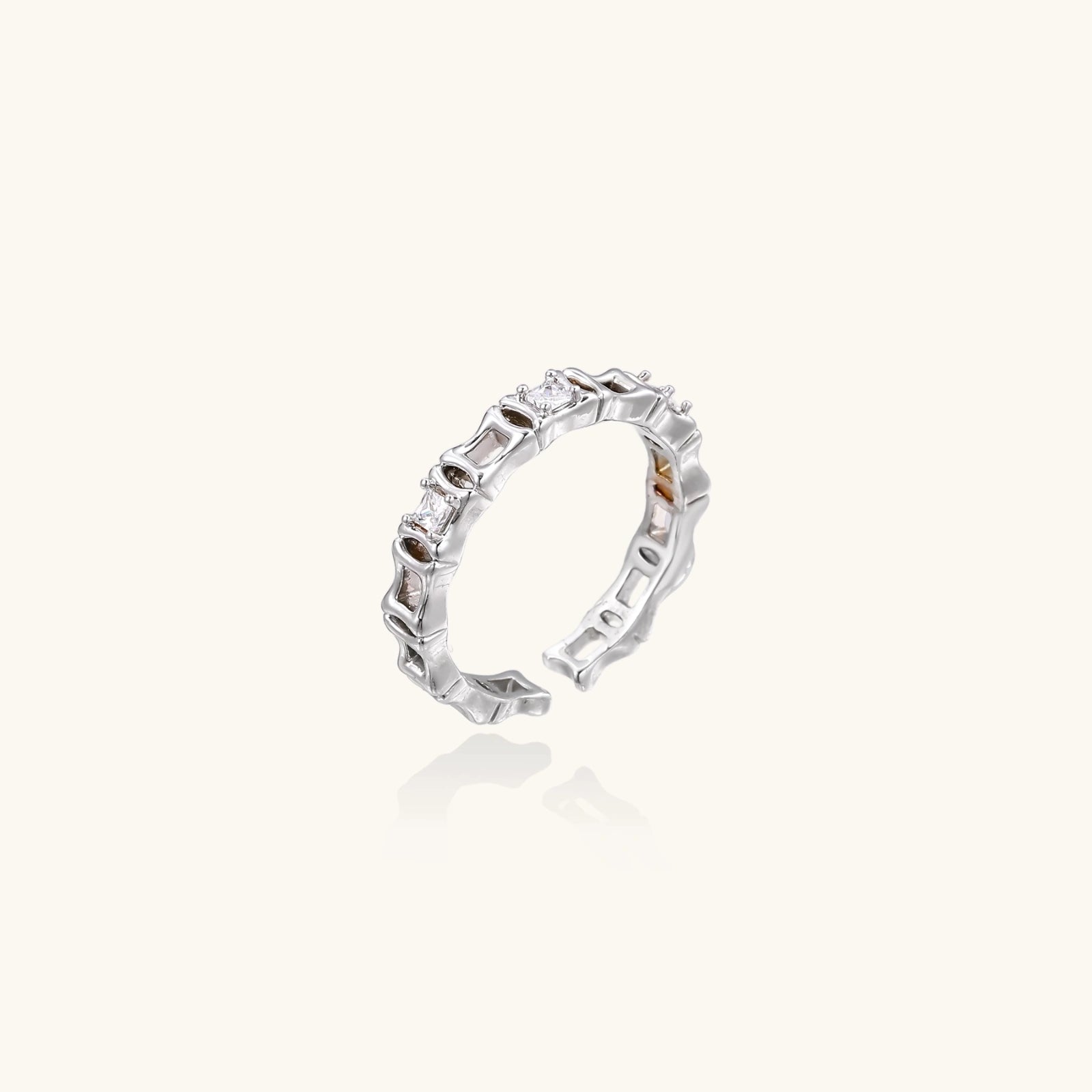 White gold plated ring with architectural lattice design and zirconia accents on cream background